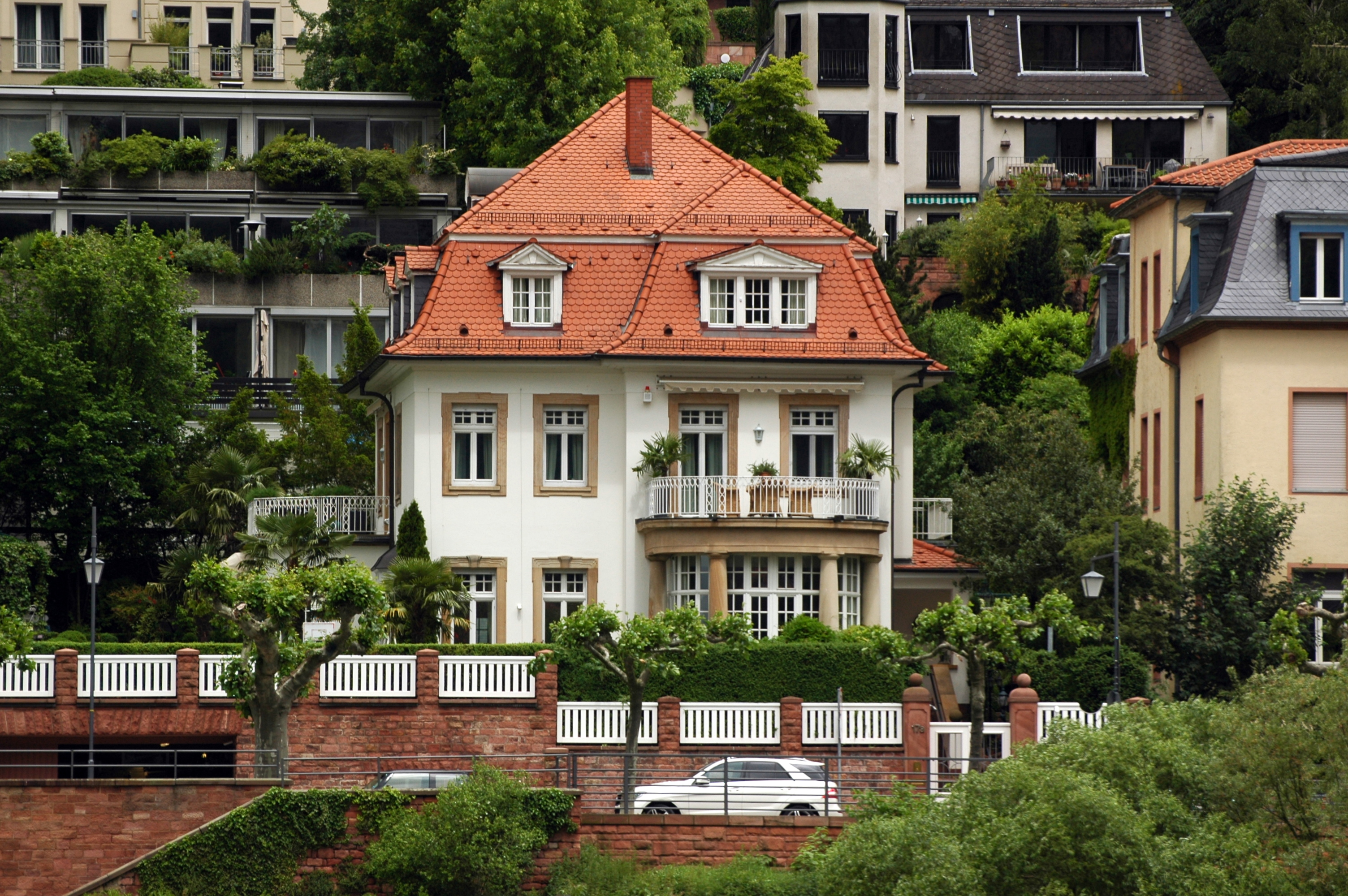 Villa Marstall’s pale 19th-century facade beneath leafy trees in Heidelberg’s Old Town