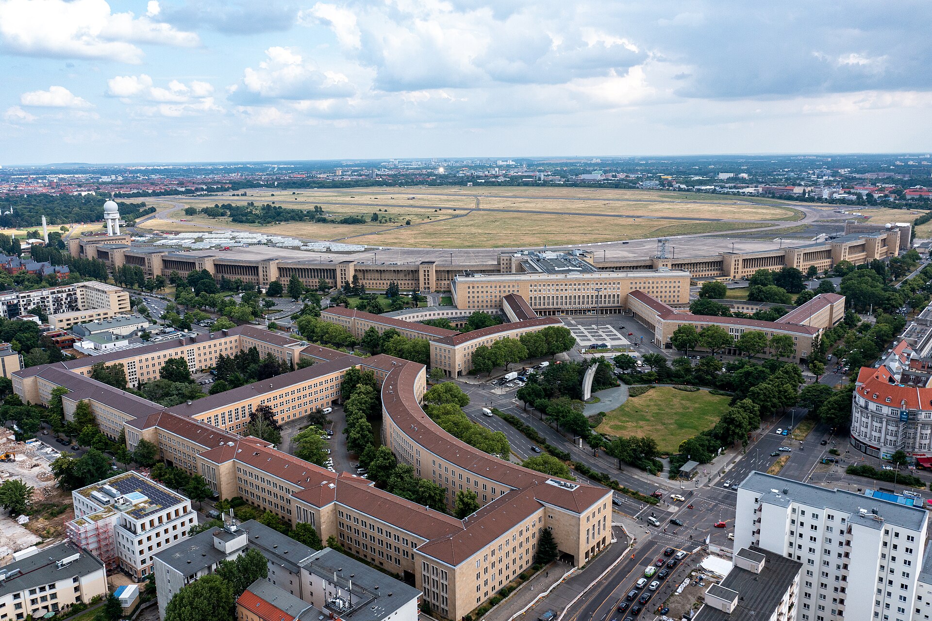 The Airlift Memorial at Tempelhof — three curved prongs reaching skyward, with the vast terminal building behind